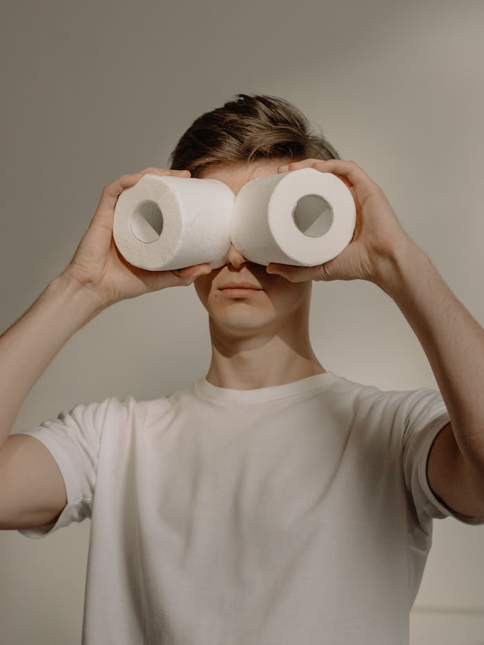 Man in White Crew Neck Shirt Holding 2 White Tissue Rolls